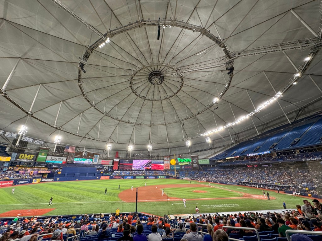 Wide interior view of Tropicana Field showing the baseball field and spectator seating beneath the dome.