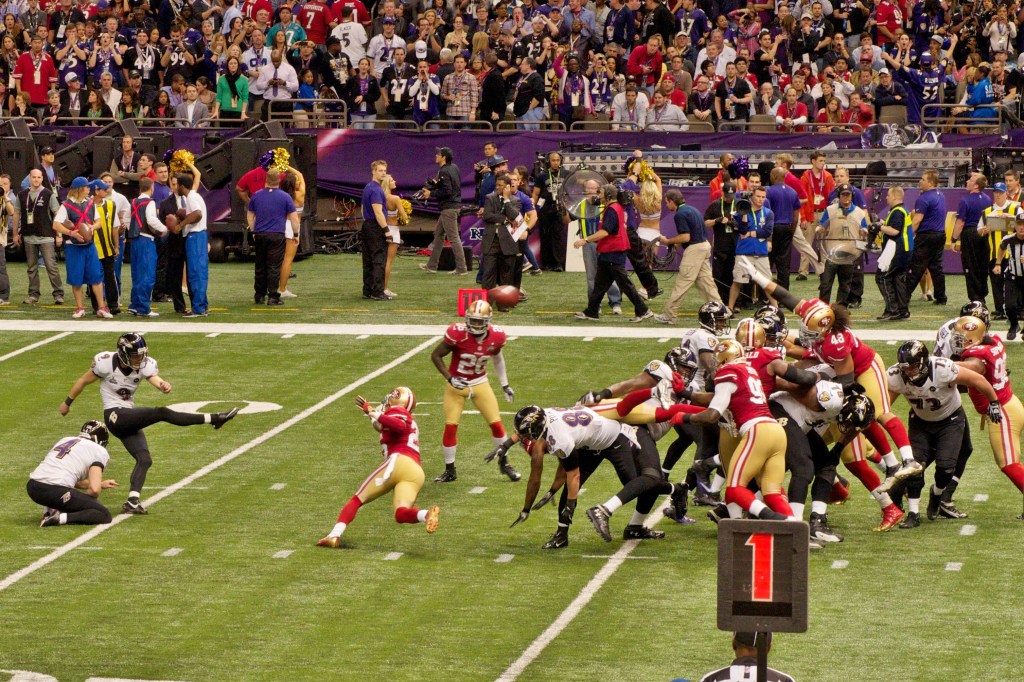 Justin Tucker, wearing a white Baltimore Ravens No. 9 jersey, kicks a field goal during Super Bowl XLVII.