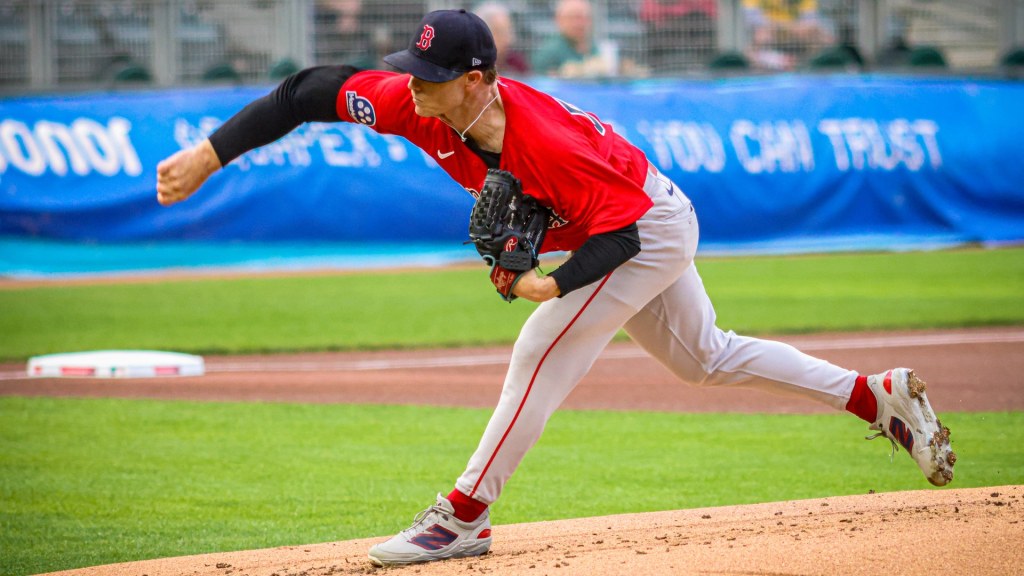 Sonny Gray, in a red Boston Red Sox jersey and gray pants, follows through on a pitch from the mound against the Minnesota Twins